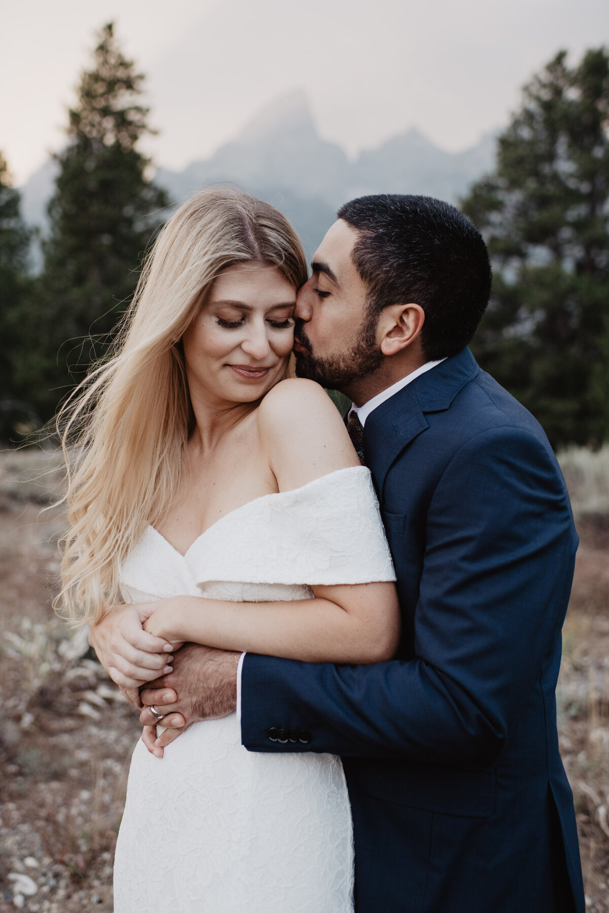 Photographers Jackson Hole capture groom kissing bride's cheek in Grand Teton National Park