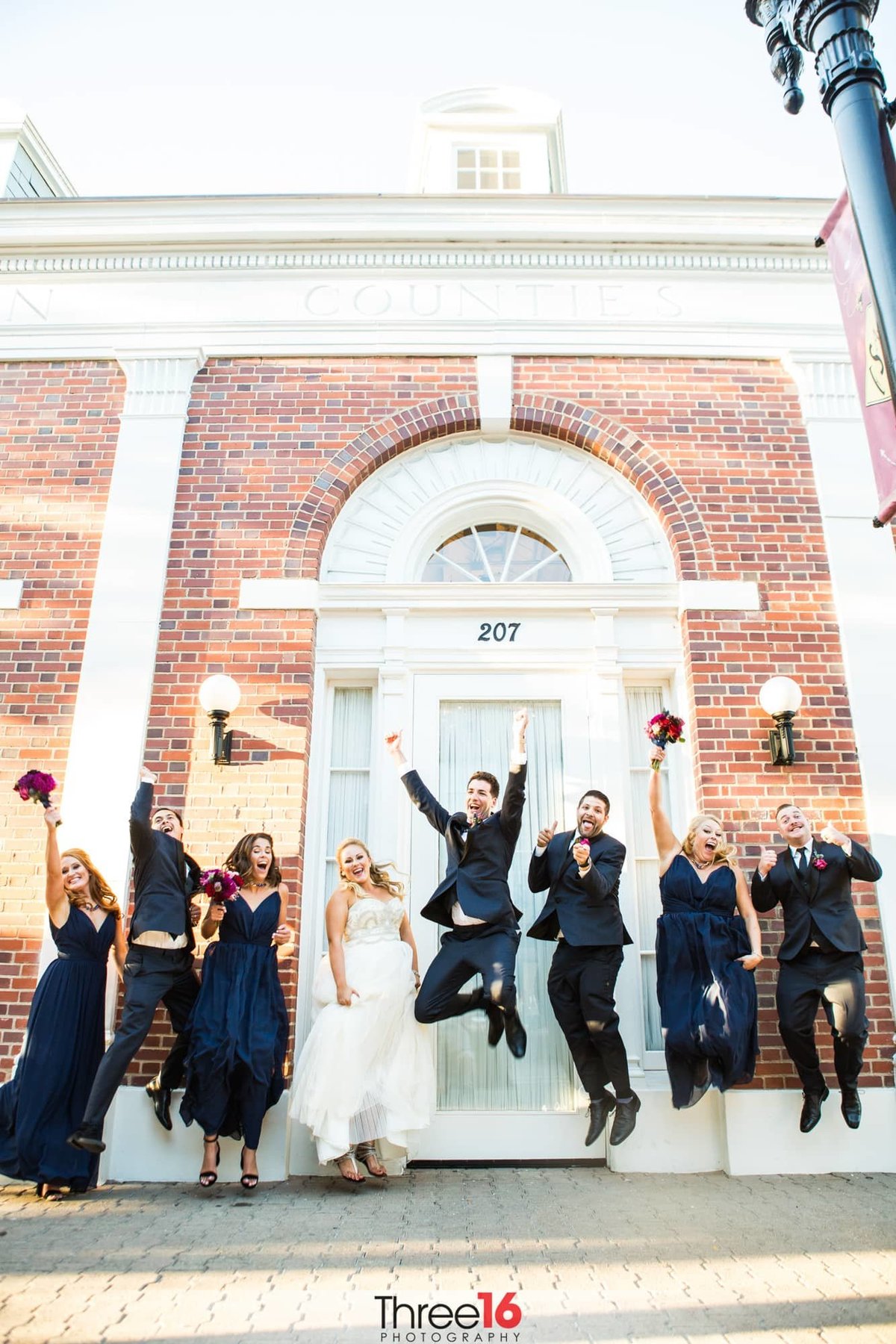 Wedding party jumps for joy during photo session