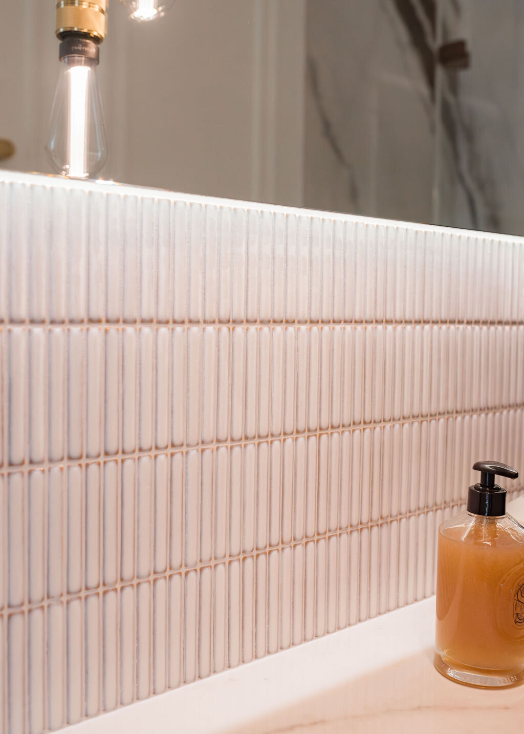 Close-up look at the white tile backsplash in a modern bathroom.