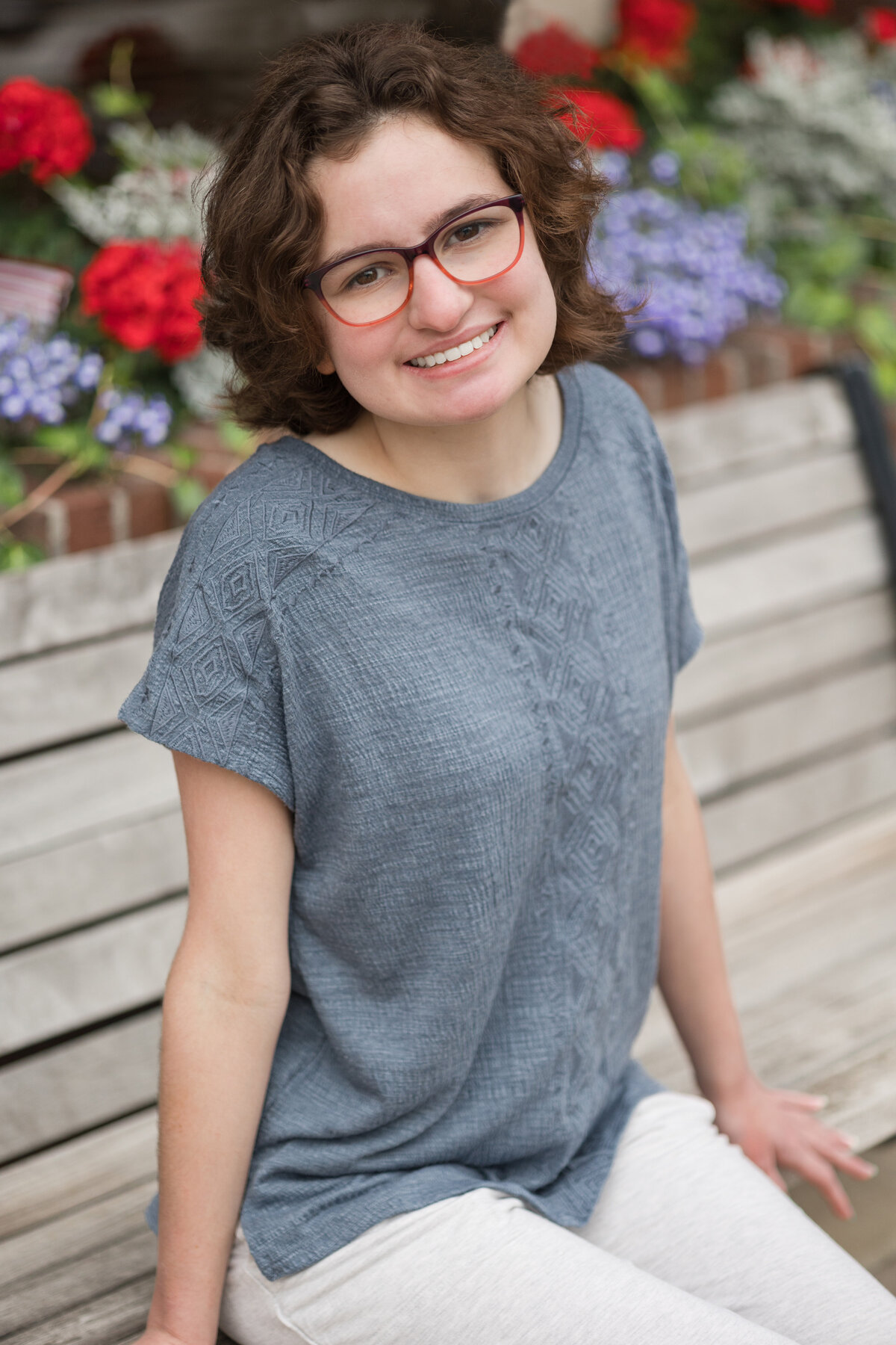 Senior girl sitting on a bench smiling at the camera