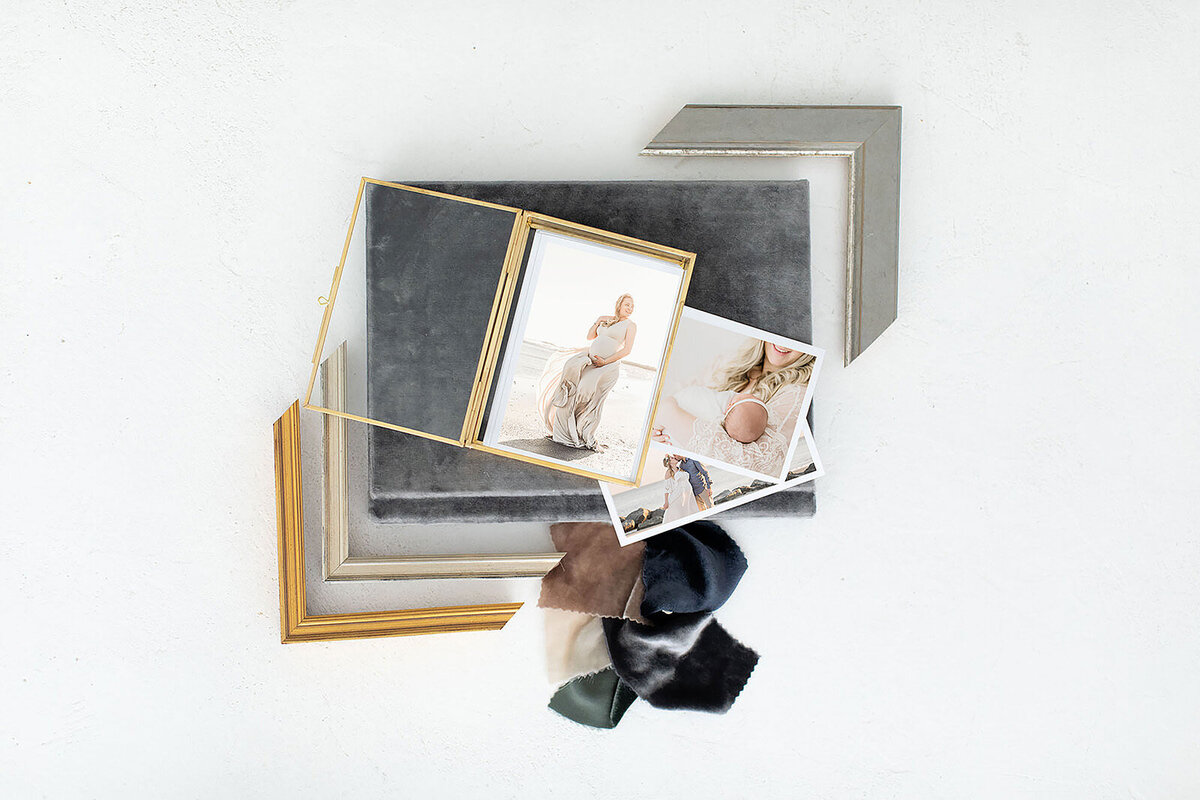 Linen-bound family photo albums and fabric swatches on light backdrop