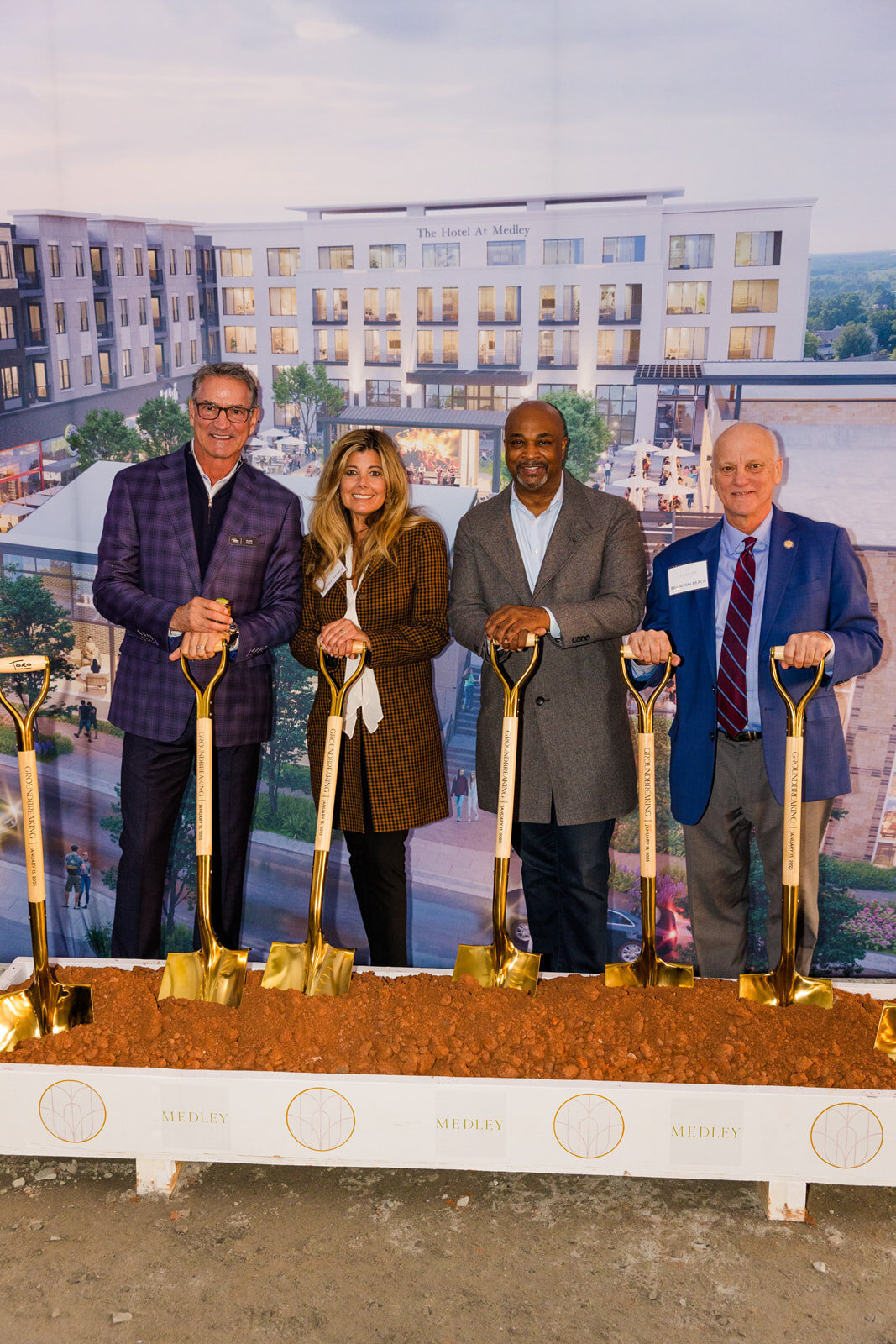 people holding shovels in dirt during ground breaking GA Medley mall event