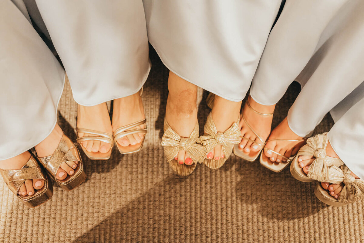 bridesmaids put their feet together for a semi circle of fancy shoes.