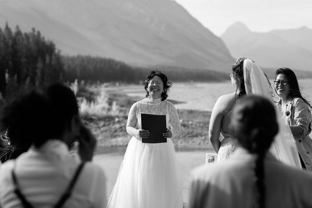 Bride smiling in mountains by Court Amber Photography, joyful and adventurous wedding photographer in Calgary, Alberta. Featured on the Bronte Bride Vendor Guide.