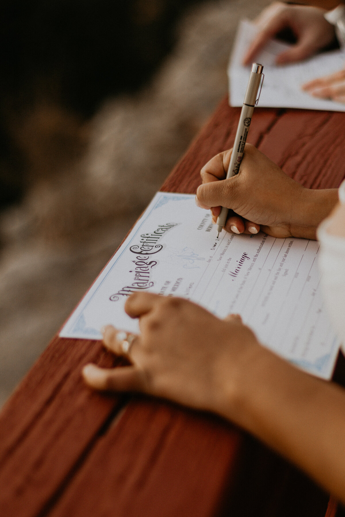 bride and groom signing paperwork on Sandia Peak Tramway boardwalk overlooking Albuquerque