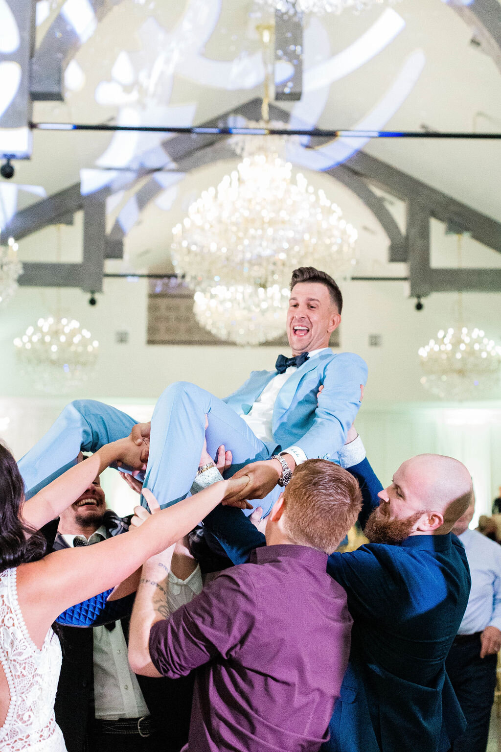 Groom being lifted by guests at peach orchard wedding in houston, texas