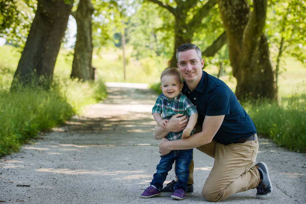 A family enjoying playful hugs, showcasing connection and joy during a spring mini session at Valley Forge.