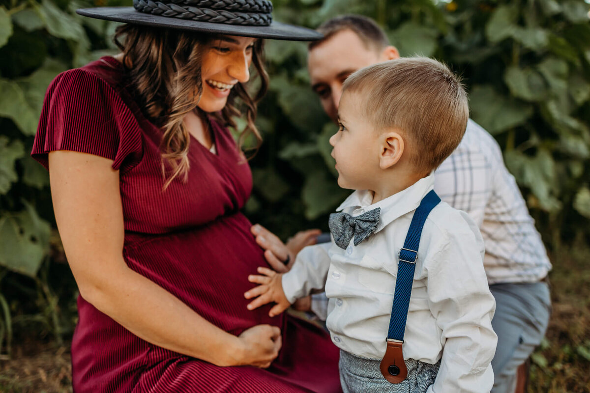 Adorable mom and son holding belly maternity image