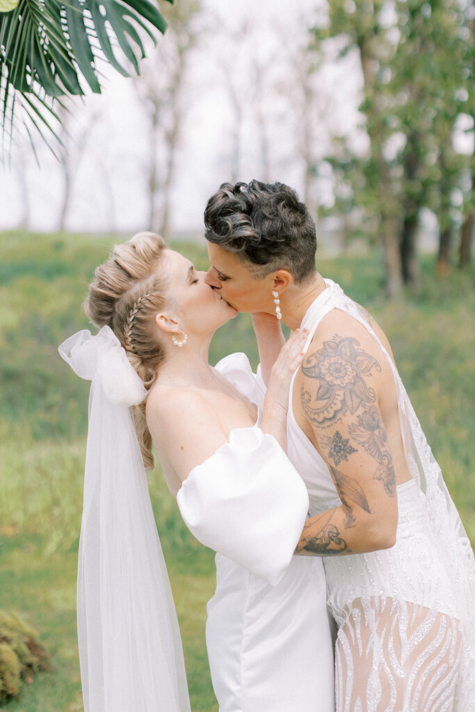 Couple kissing during wedding ceremony at Sugar Pine Island, a romantic wedding venue in Foothills, Alberta, featured on the Brontë Bride Vendor Guide.