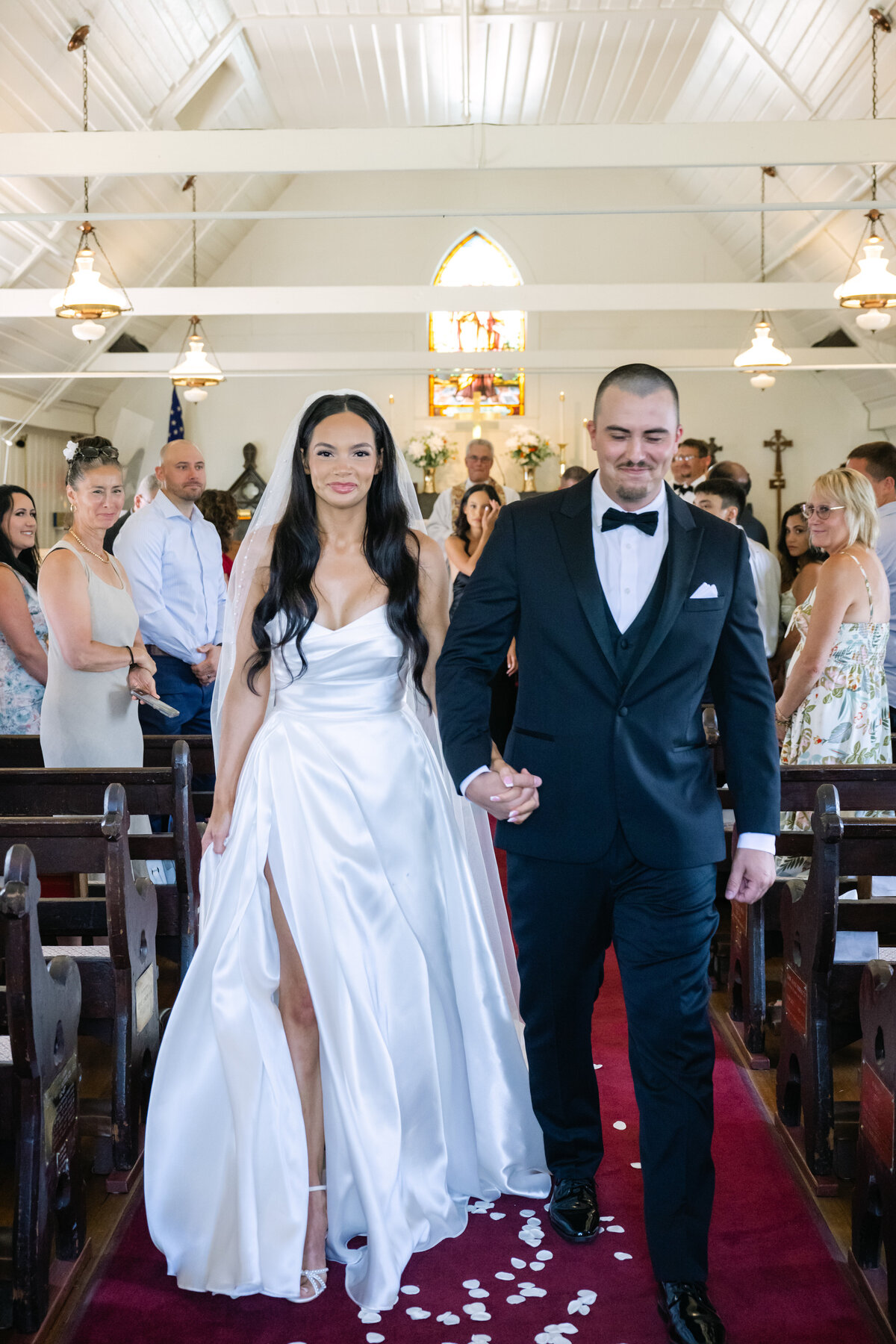 just married bride and groom smiling at white chapel in tacoma