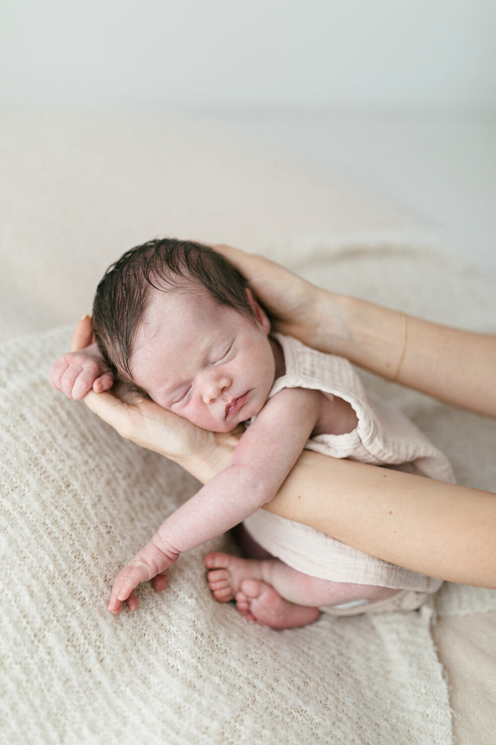 Baby is help in mums hands asleep