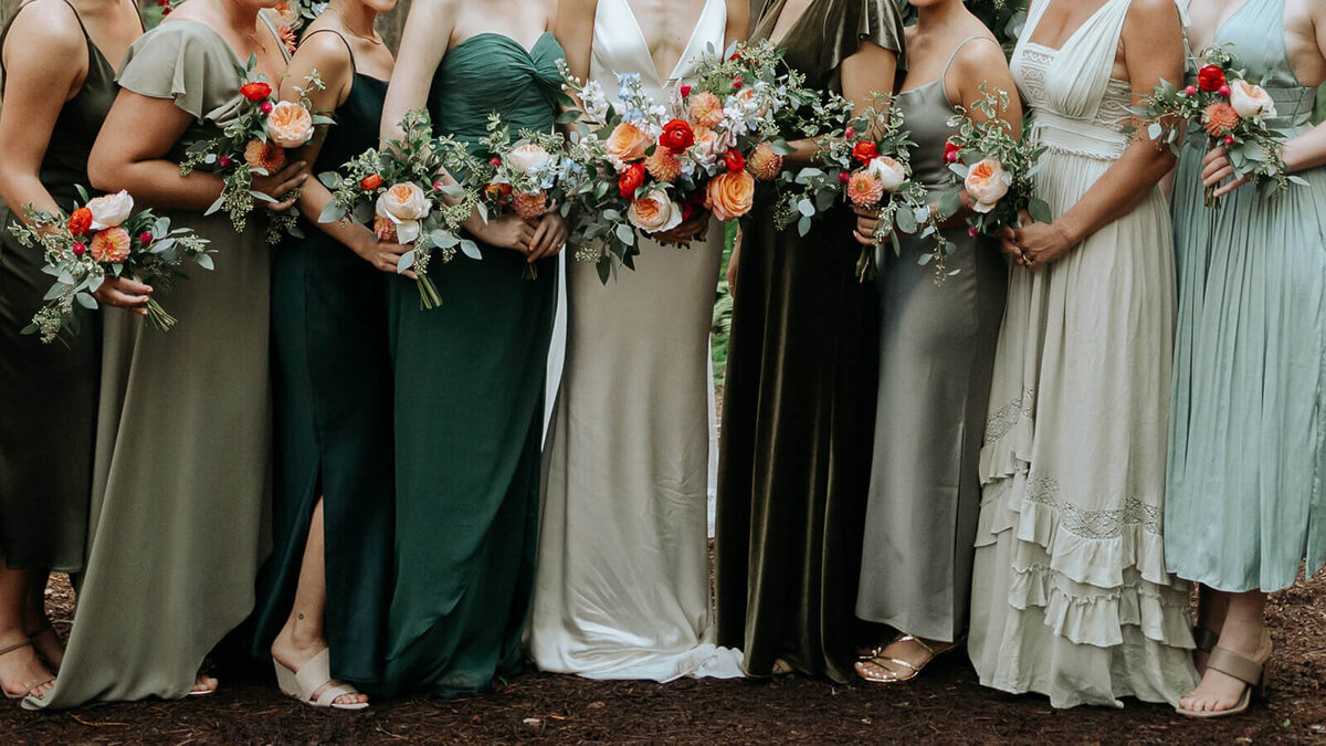 A wedding party with mismatched bridesmaids in shades of green