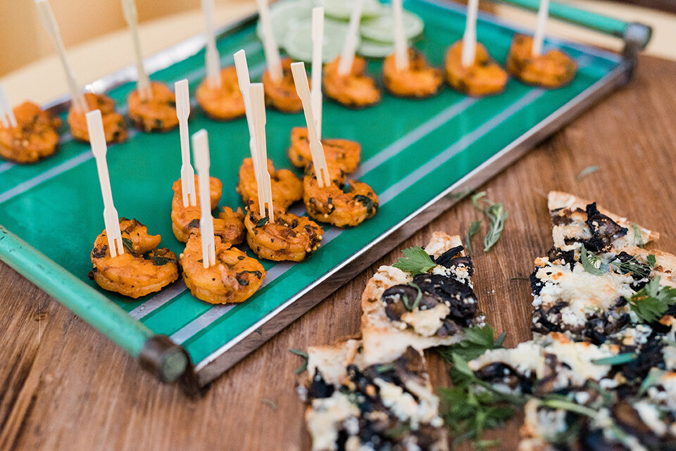 Hors D’oeuvres are set on a tray atop a wooden table.