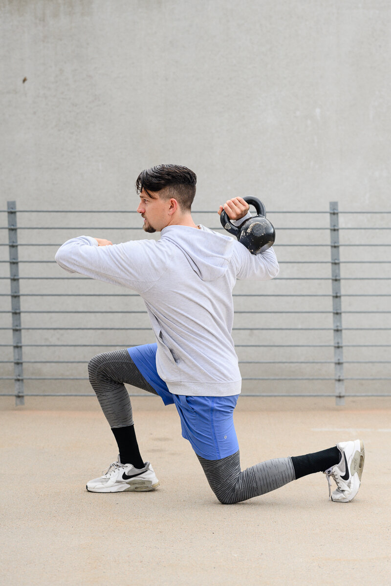 A commercial photographer in Denver takes brand photos during a branding photography session for a fitness coach doing lunges with weights for his branding photos and brand photos.