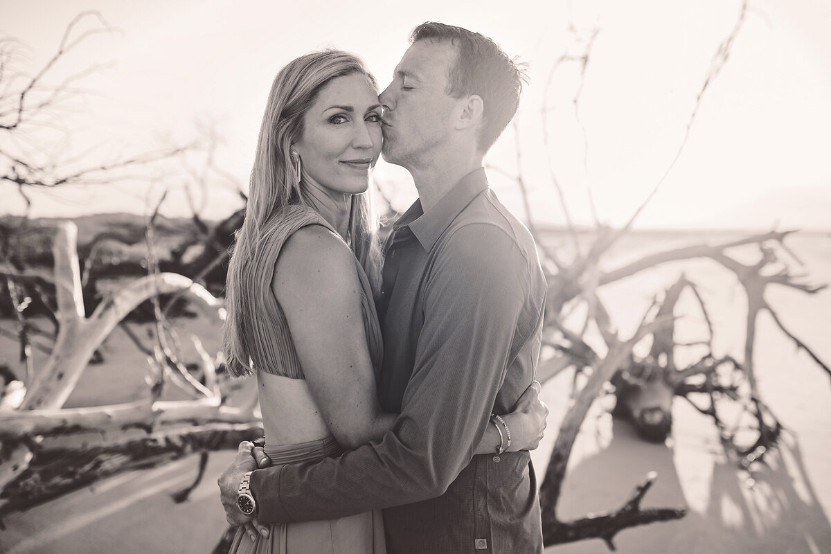 Husband kisses his wife during Family Photoshoot on Folly Beach. 