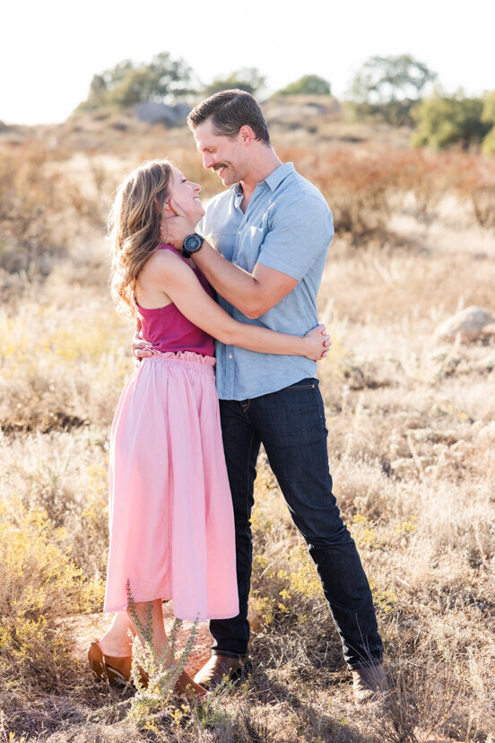 couple-hugging-in-family-of-four-sitting-on-rock-wrights-field-san-diego