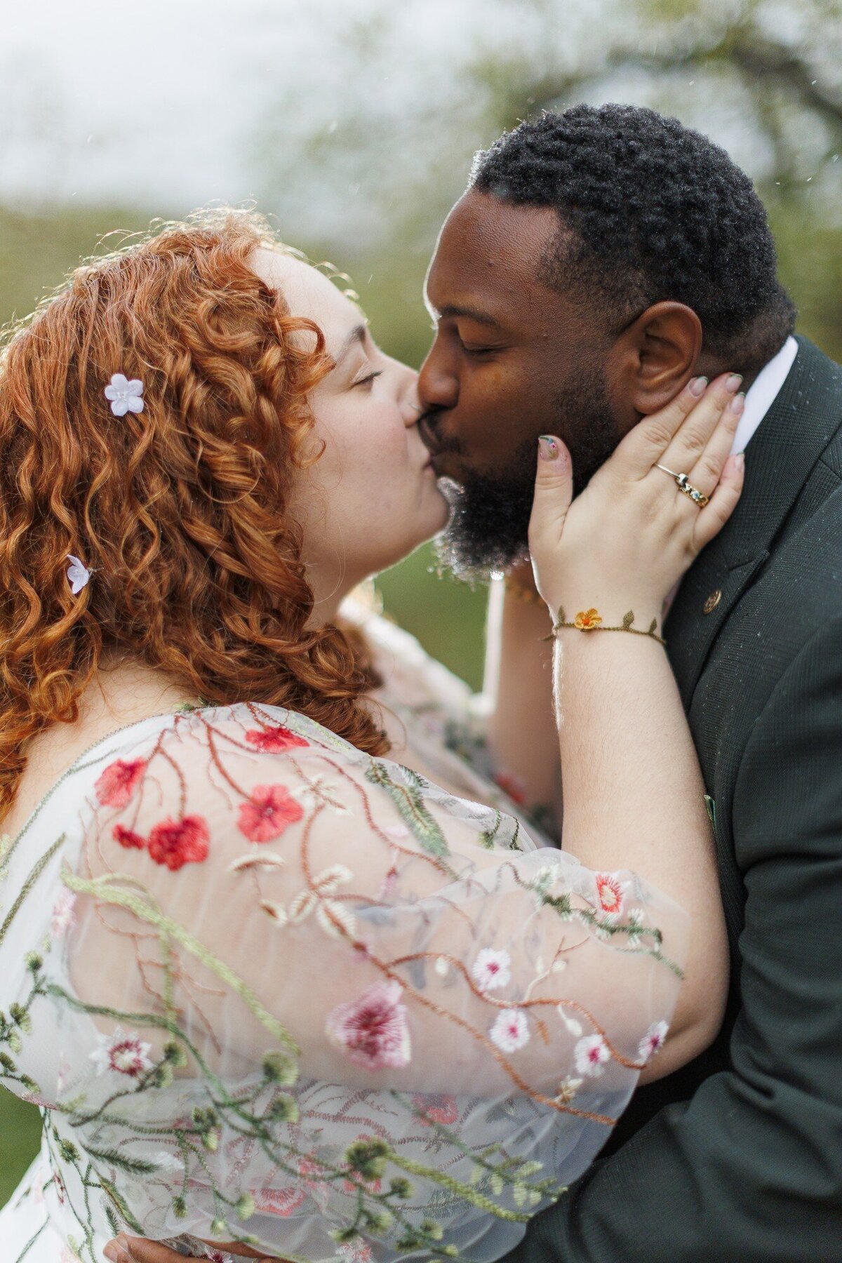 Bride in an embroidered floral dress kissing her groom at a Hudson Valley wedding