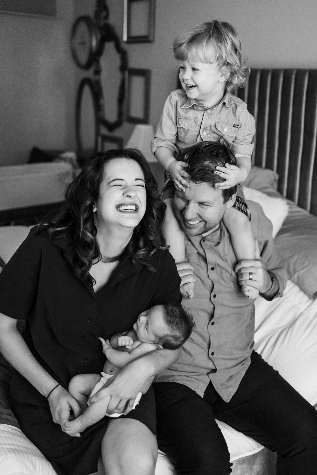 Family of four playing on bed during a newborn session
