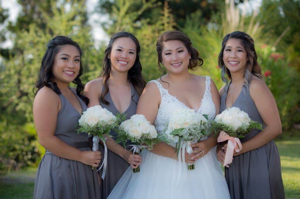 Bride with her bridesmaids wearing lavender smiling looking at the camera, Photo by wedding photographer from Sacramento, Philippe Studio Pro.