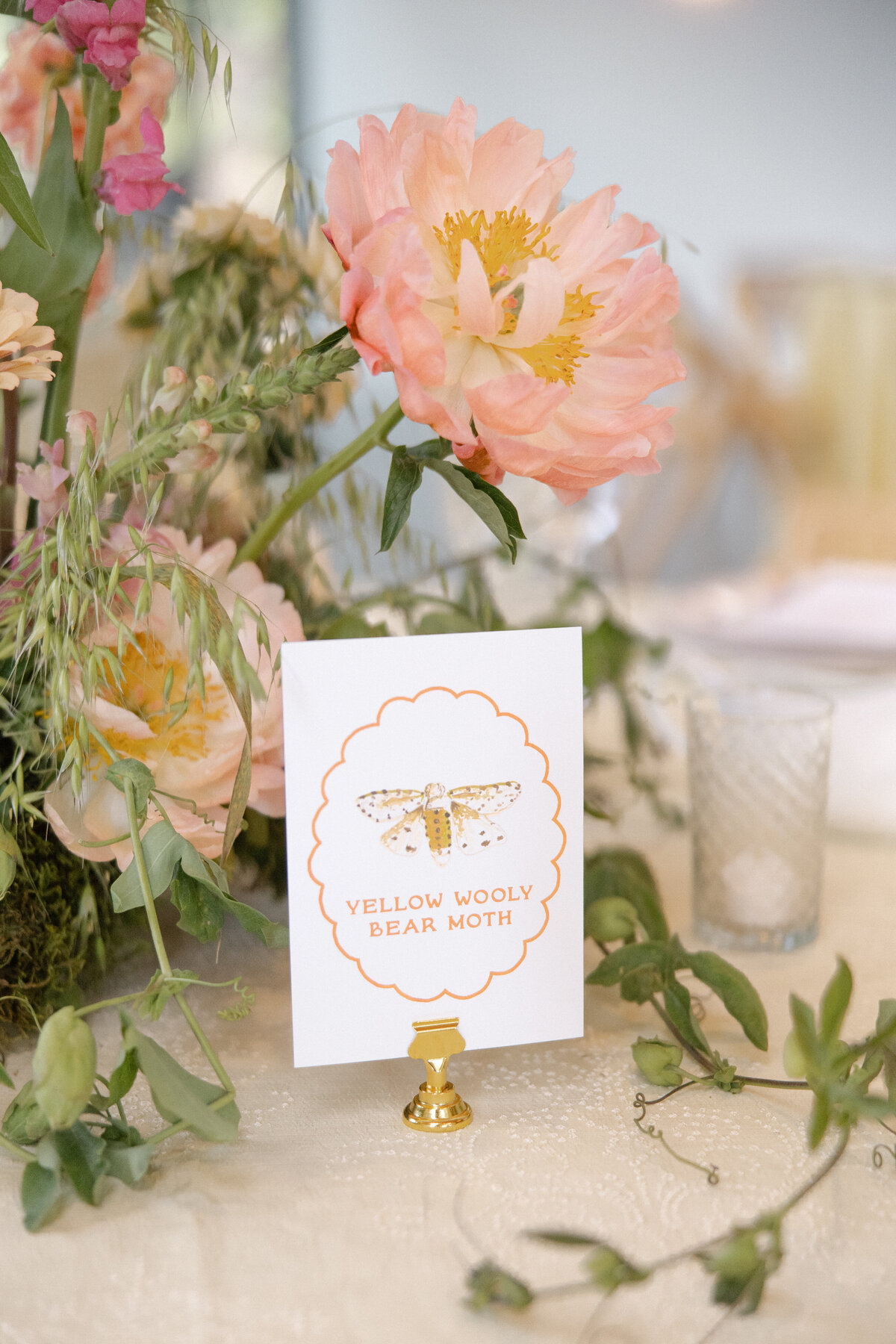 Colorful garden party wedding reception table with a handpainted watercolor insect table number and modern typography by Dear Margo Designs with flower arrangements by Lovelilly Floral