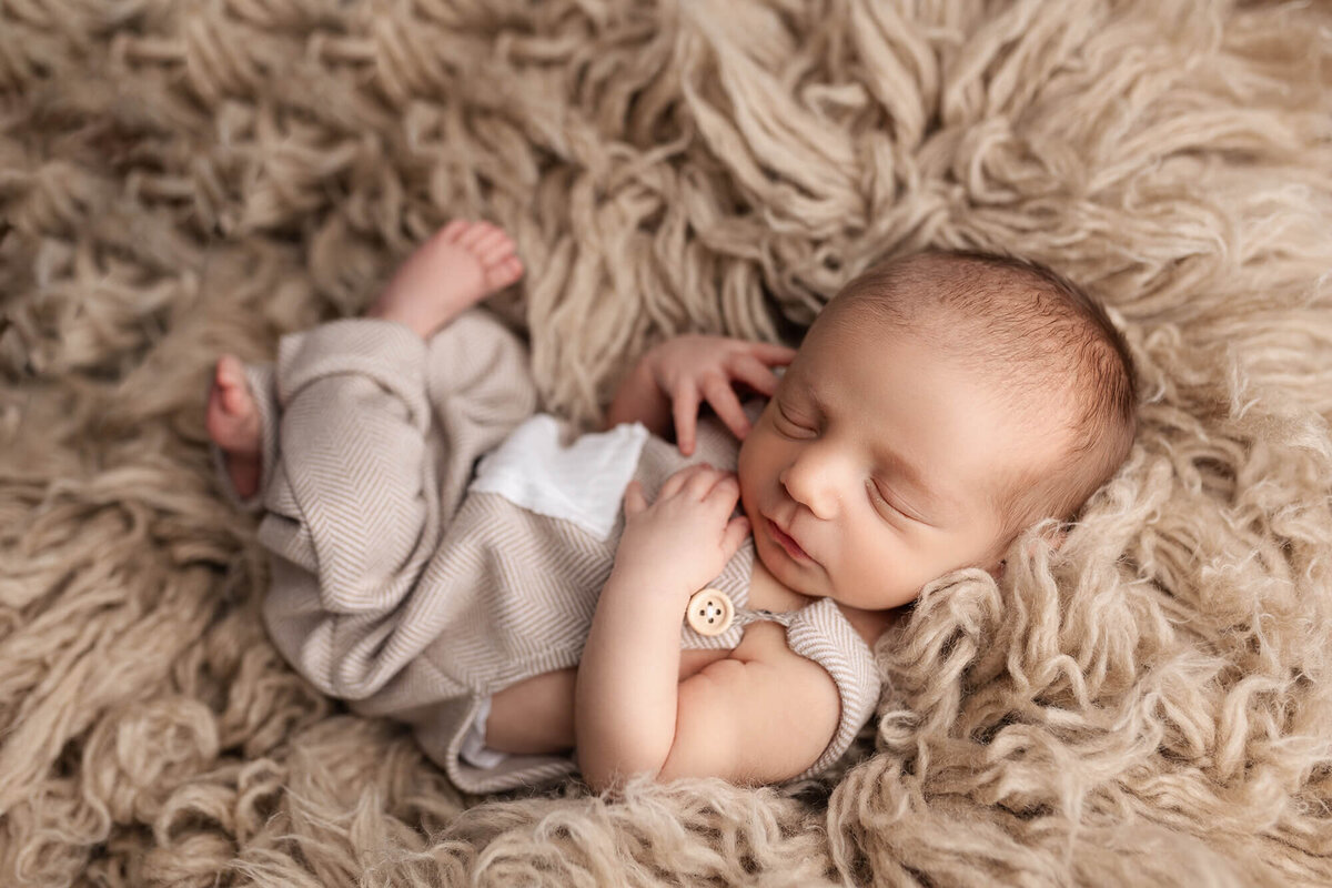 Tiny newborn posed during his newborn photography session.