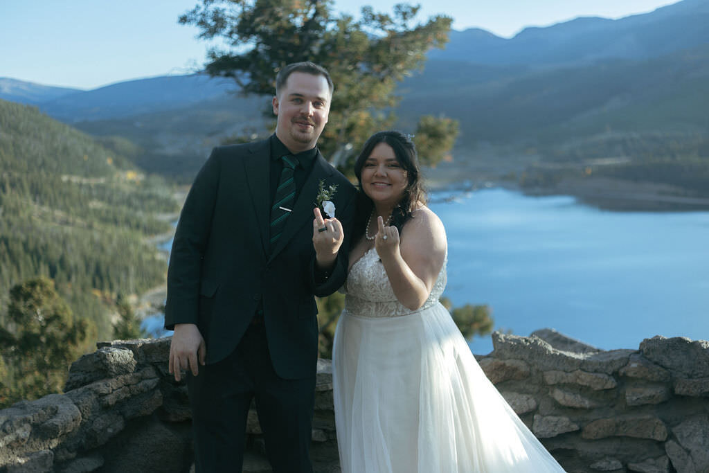 A newlywed couple holding out their ring finger.