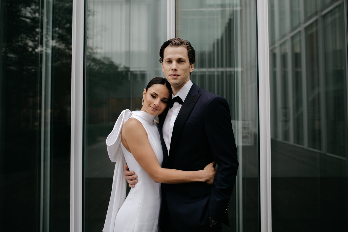 Bride hugs around Groom's waist during portraits at Art Museum of Chicago