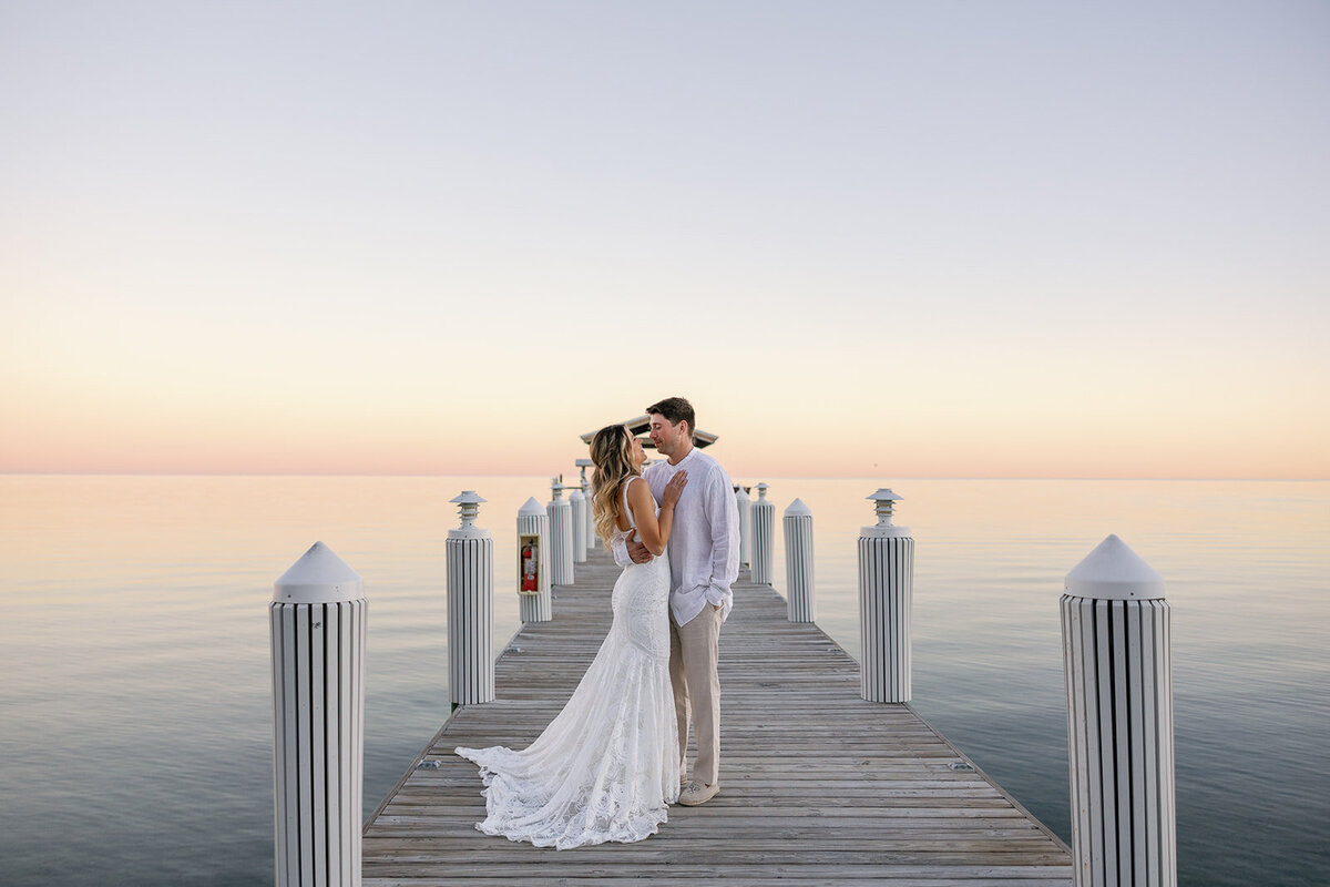 Bride Laura and groom Abraham embracing during golden hour on the dock at Cheeca Lodge Resort.