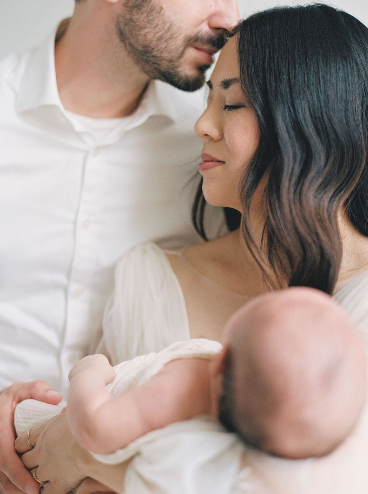 Soft studio portrait of parents and baby together, newborn photography San Francisco Bay Area.