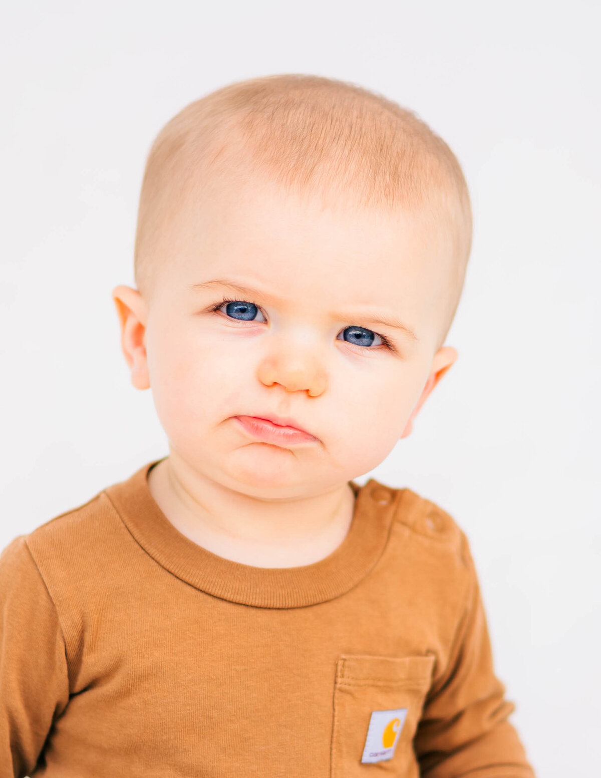 Close-up of six-month-old boy’s face with delicate details, white background