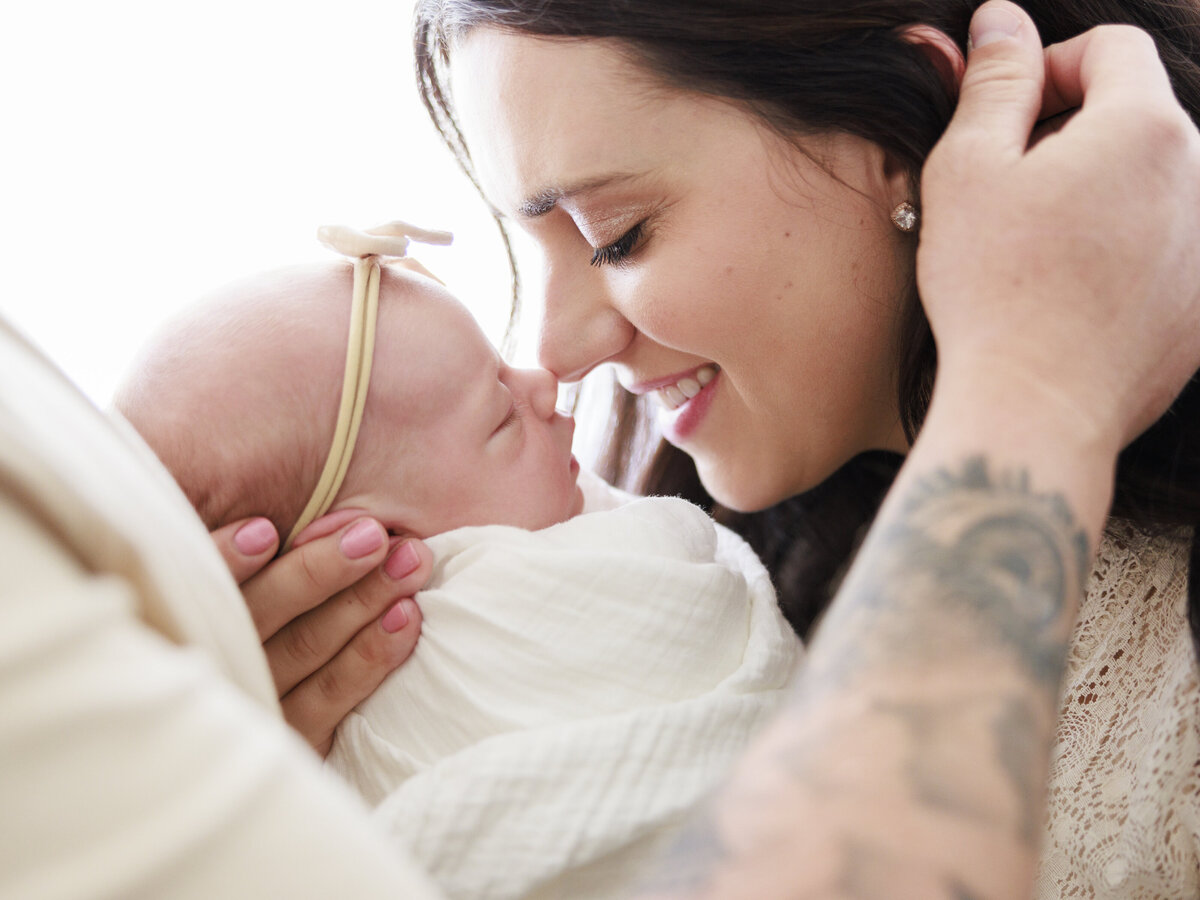 dad touching mom's hair with baby for Tampa newborn photographer Tina Marie Studio.