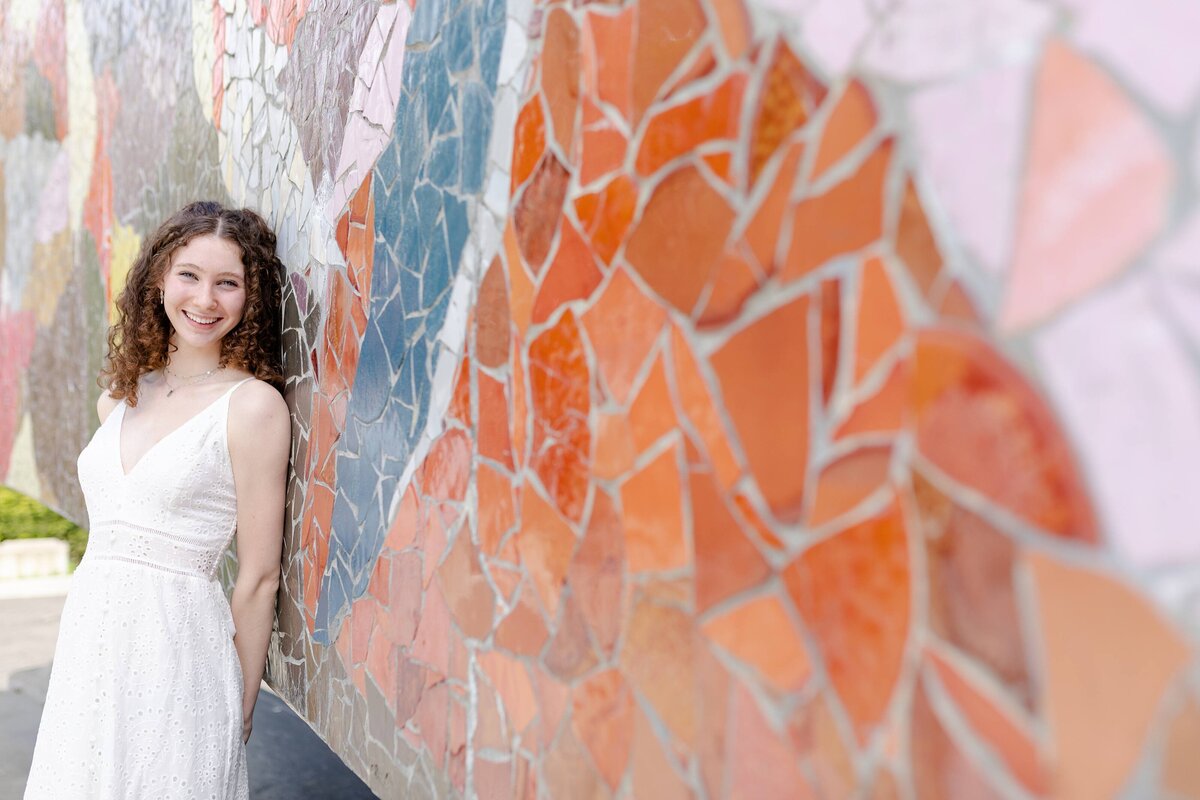 senior girl leaning on mosaic wall