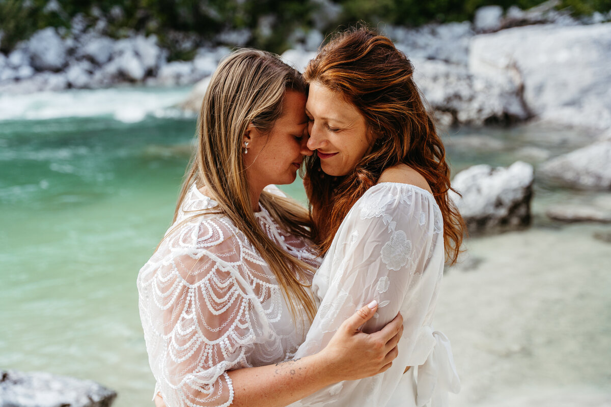lesbian couples embracing riverside elopement Slovenia