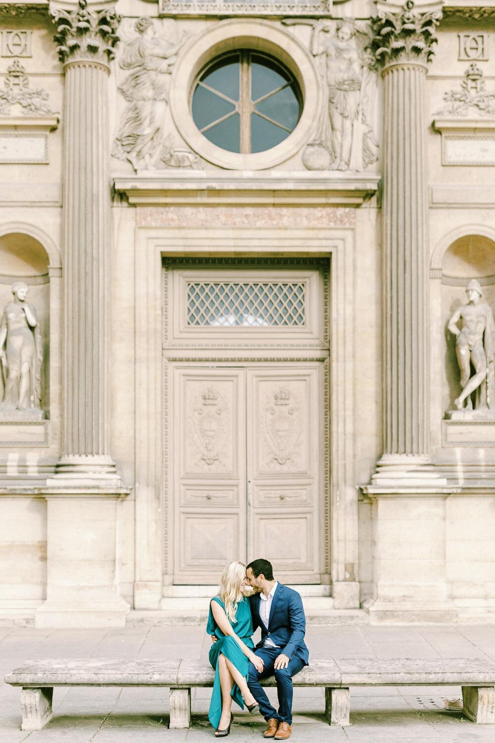 Couple sitting in front of Louver in Paris