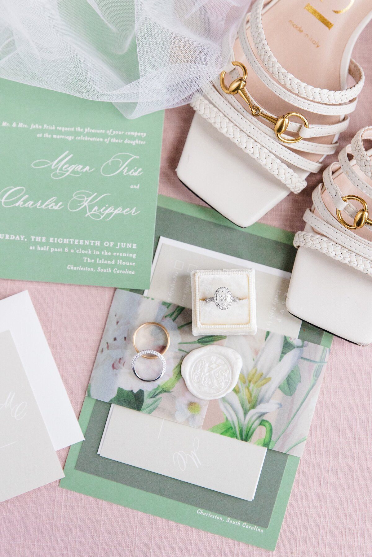 detail photo of invitation suite, bride's shoes, rings, and veil