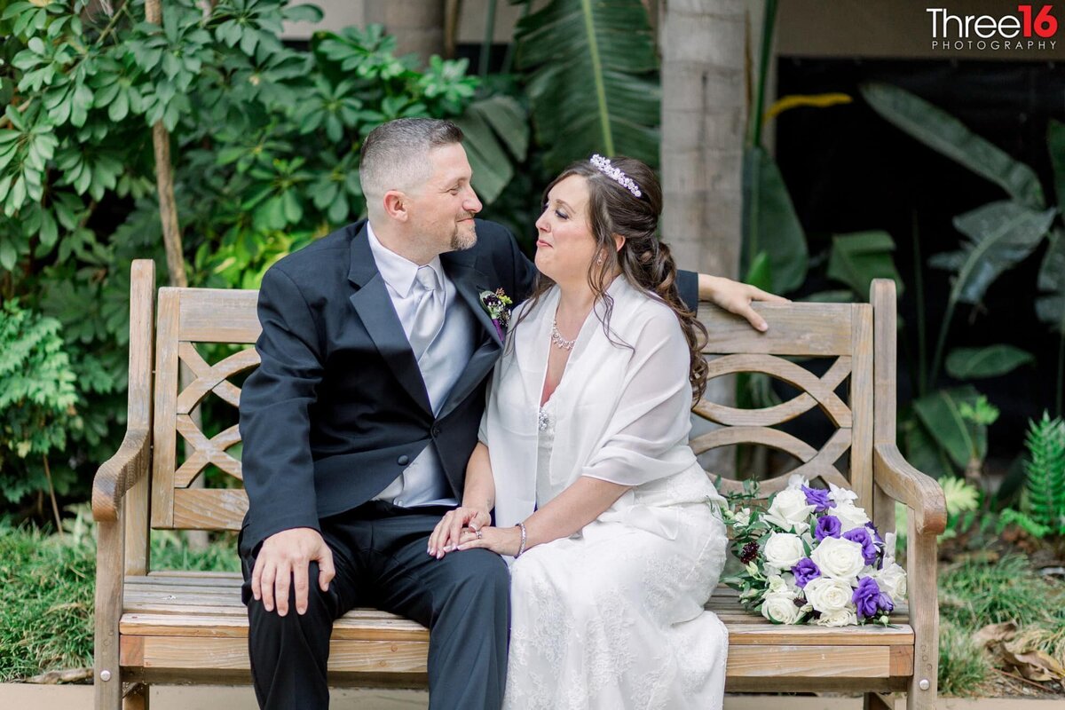 Bride and Groom sit together on a bench and talk