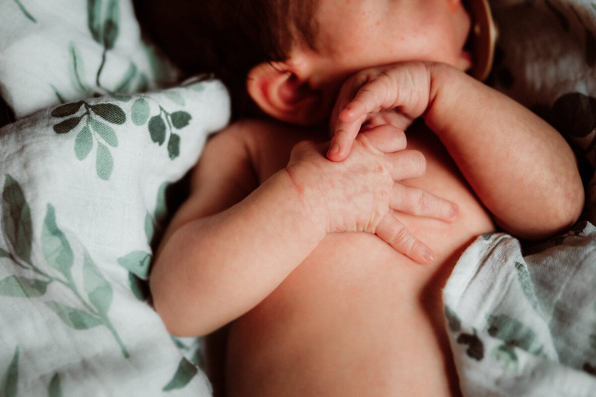 Newborn baby boy wrapped in a soft neutral swaddle during a natural light Minneapolis newborn photography session.