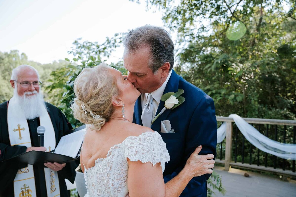 Bride and groom's first kiss during their wedding ceremony captured by Ocala Wedding photographers
