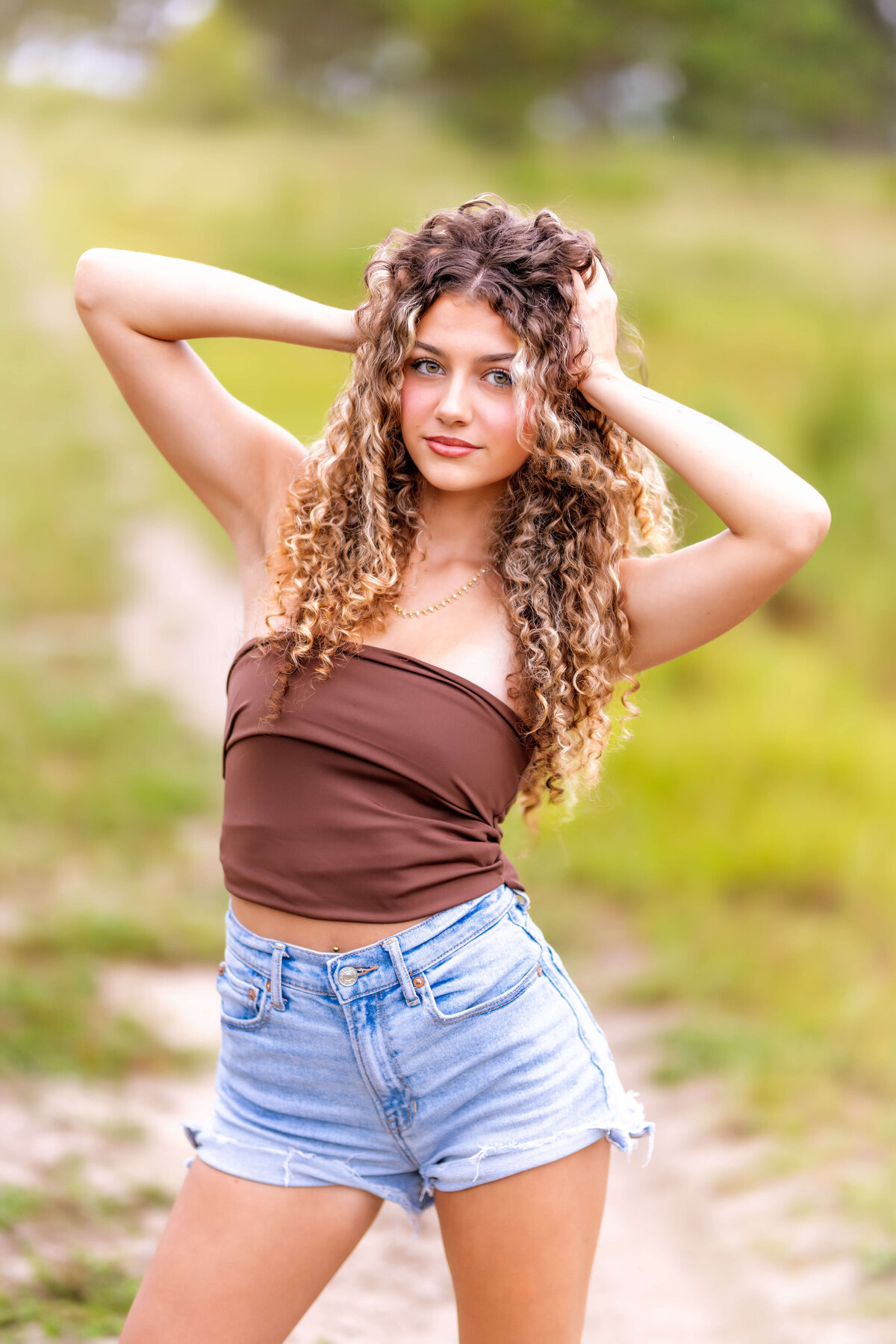 Windermere senior pictures featuring a teen girl smiling with her hands in her hair.