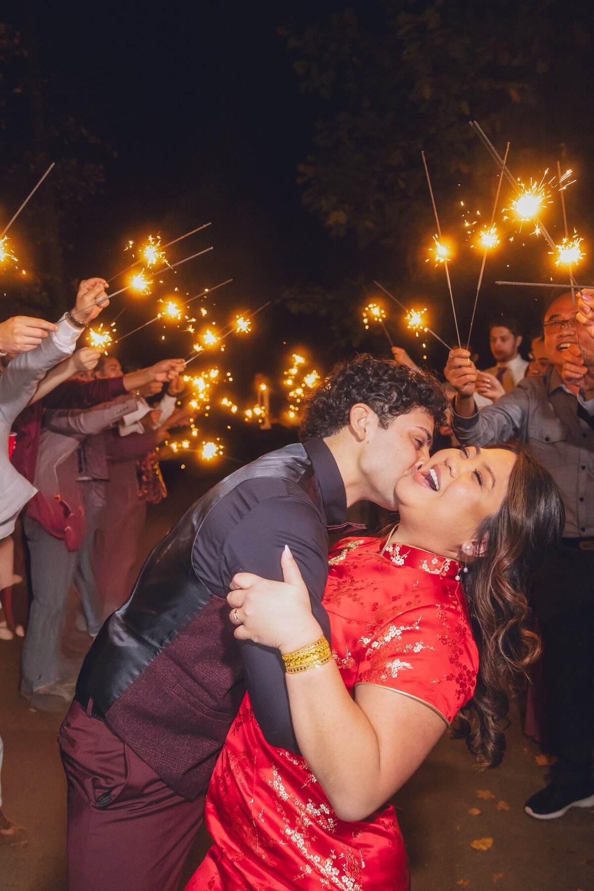 Groom dipping the bride for a kiss during the sparkler send-off.