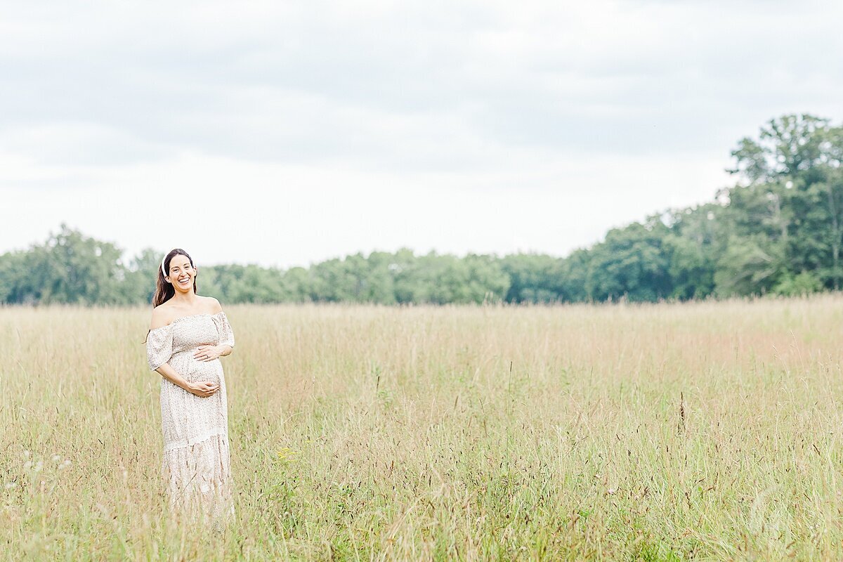 woman in field during maternity photo session at heard farm in Wayland Massachusetts with Sara Sniderman Photography