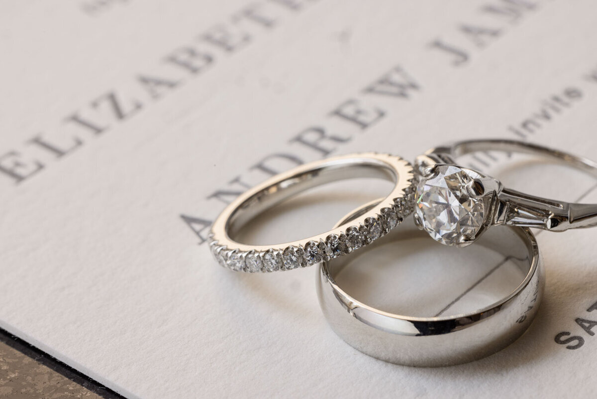 A couple of wedding rings on top of a card that says andrew
