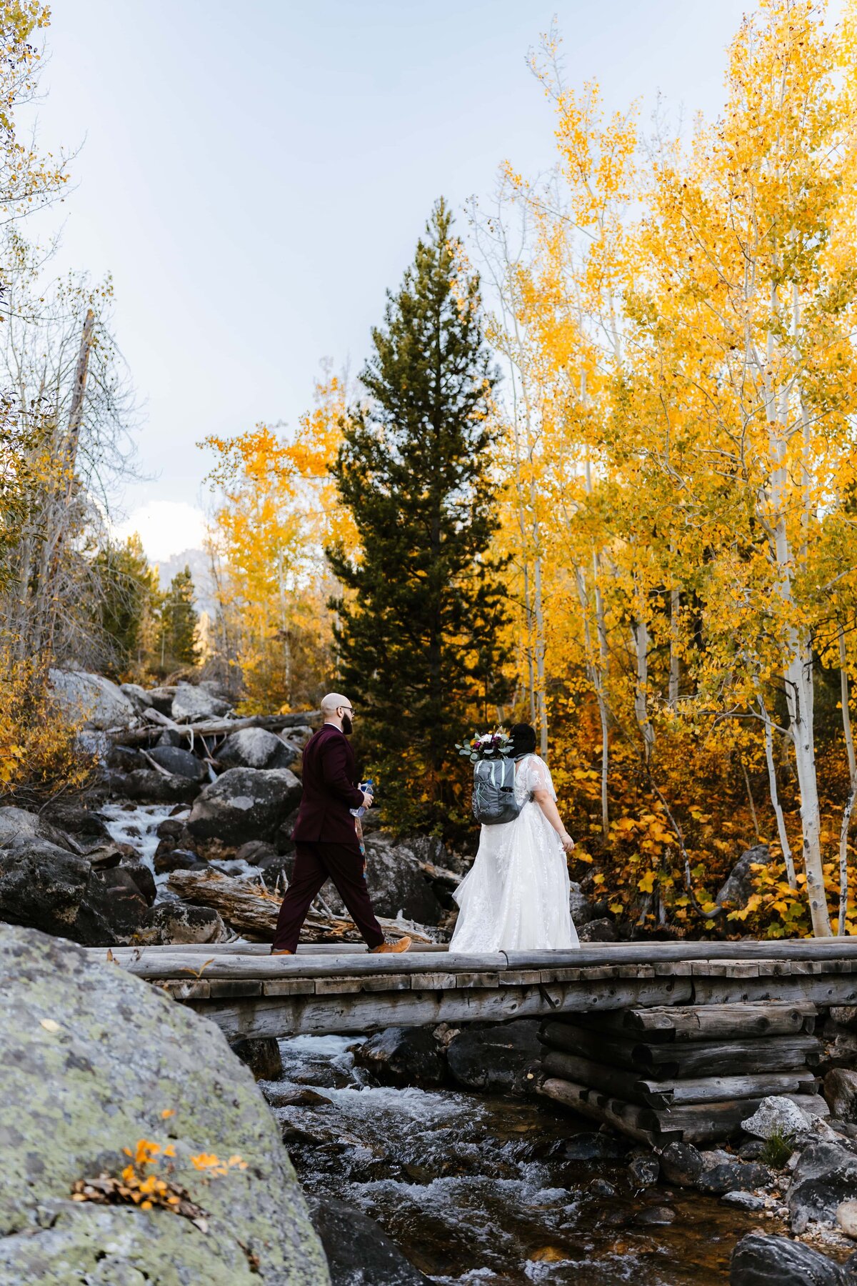 Bride and groom hiking on Taggart Lake Trail in the fall in Grand Teton National Park