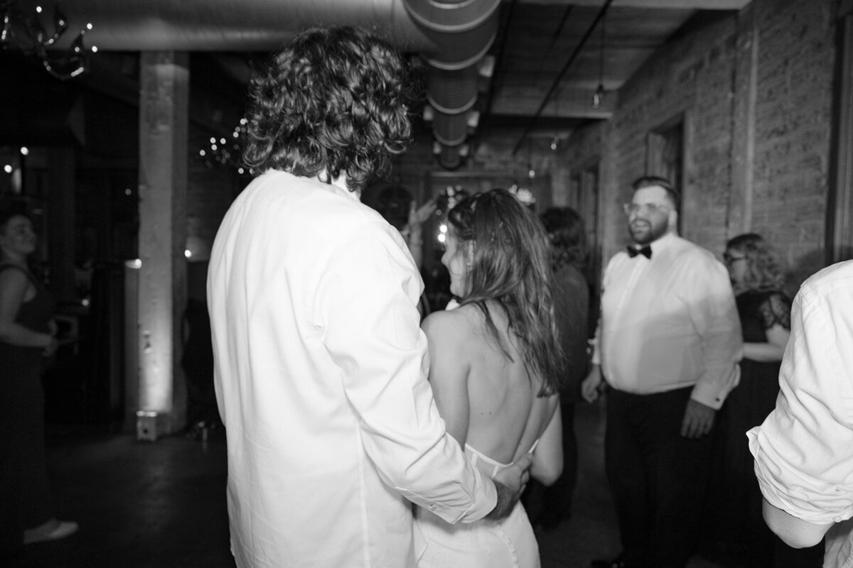 Black and white photo of bride and groom sharing a private moment at upscale San Antonio wedding reception at The Battalion