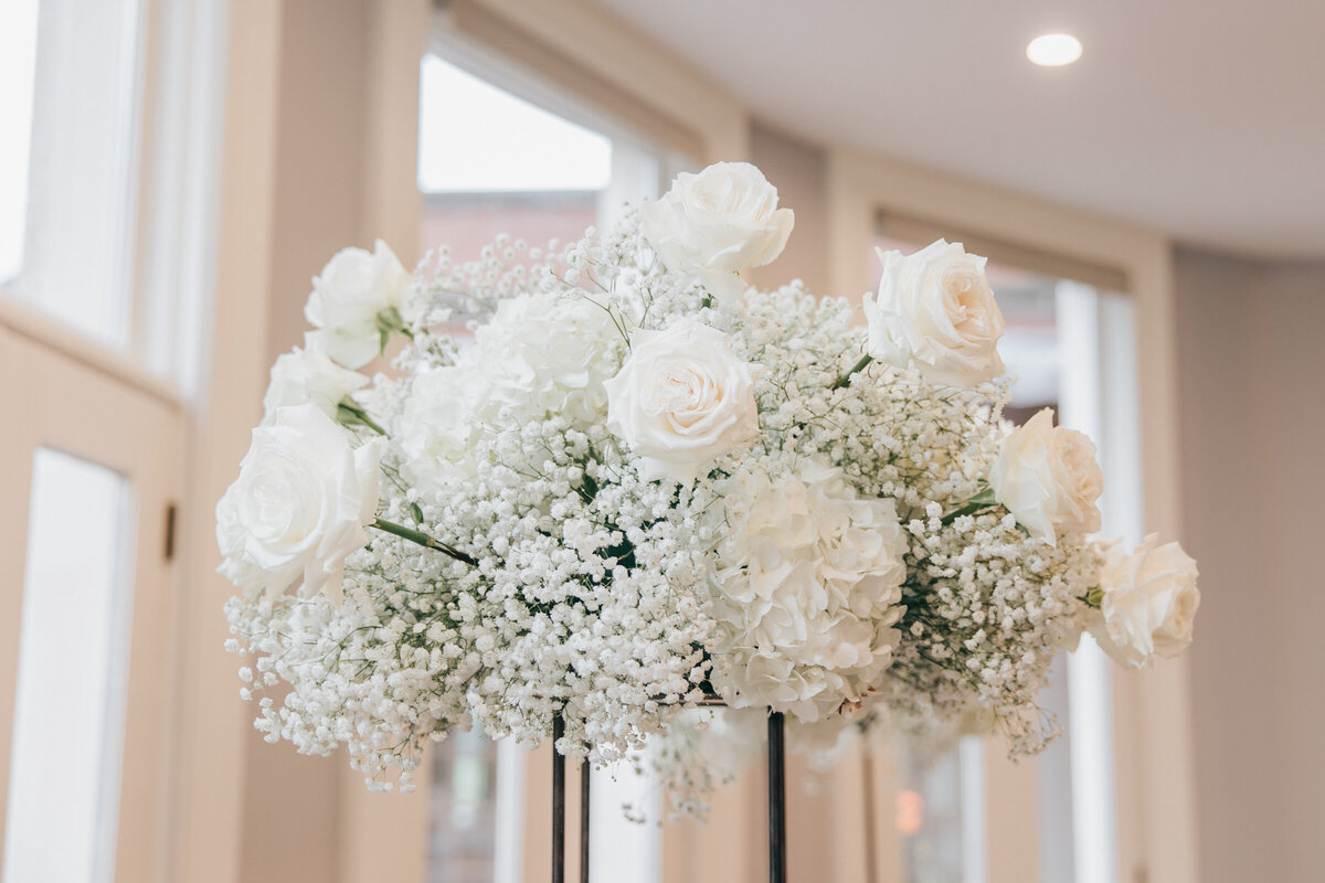 White floral arrangements for an indoor wedding ceremony