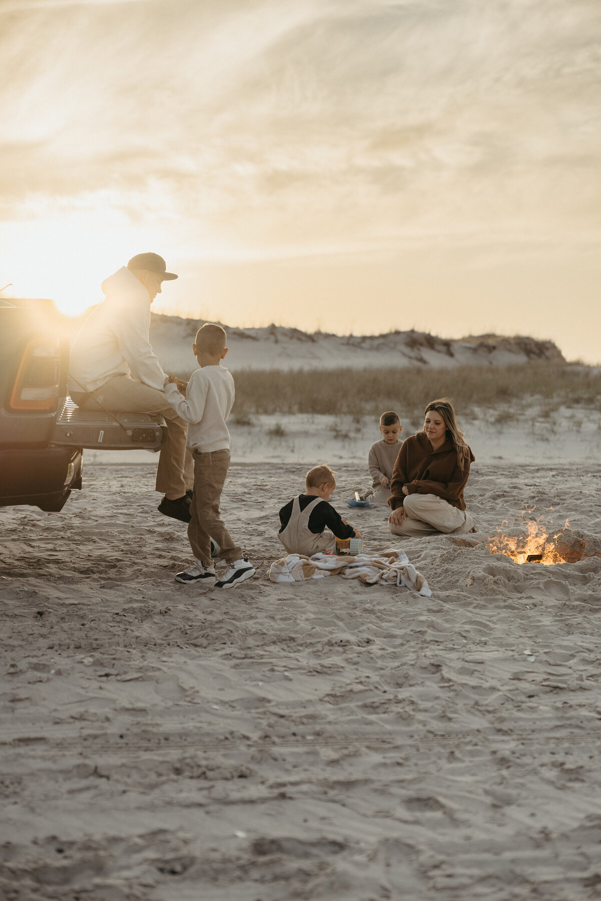 Family sitting around a beach bonfire 