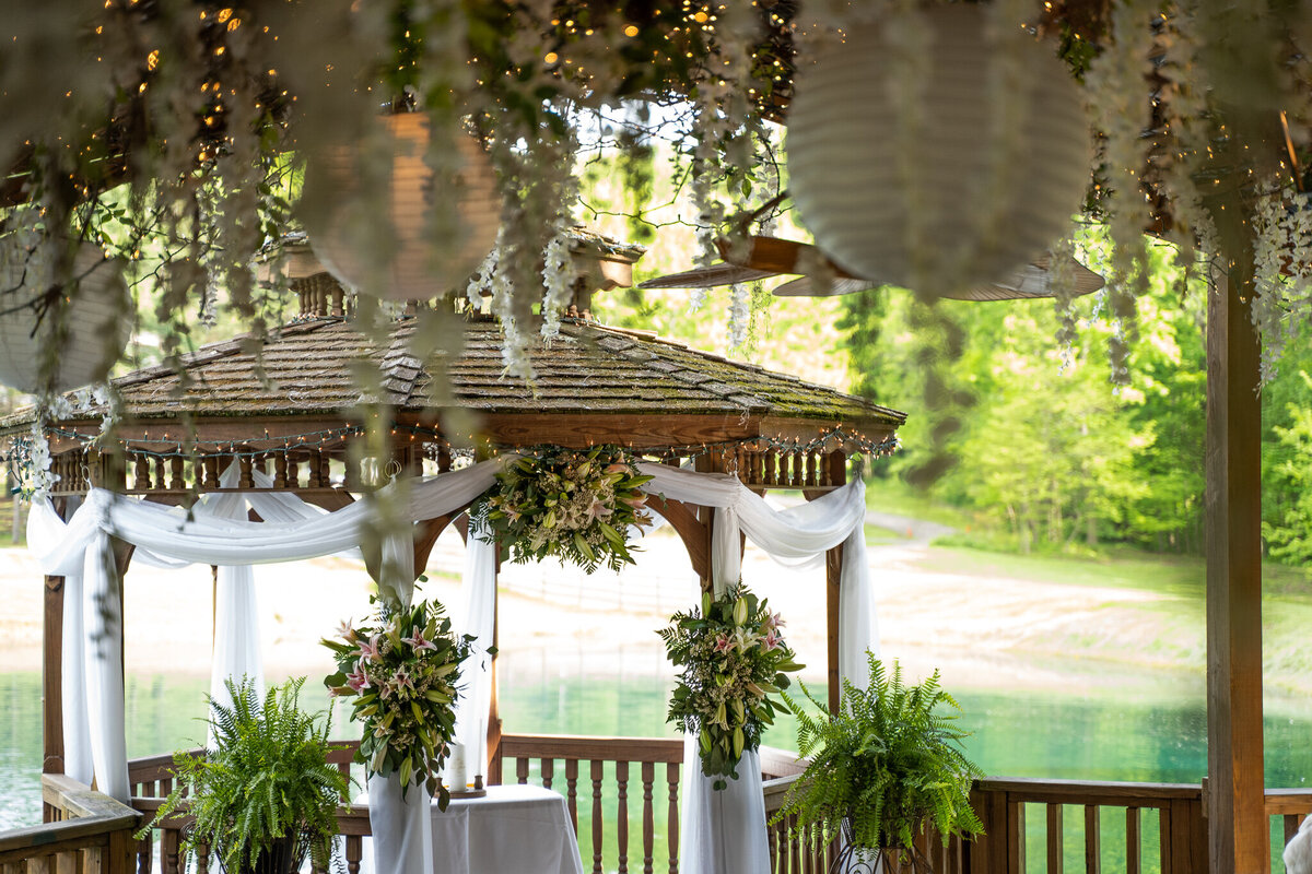 A beautifully decorated gazebo with floral arrangements and a ceiling with cascading flowers at Cheers Chalet in Lancaster, Ohio.