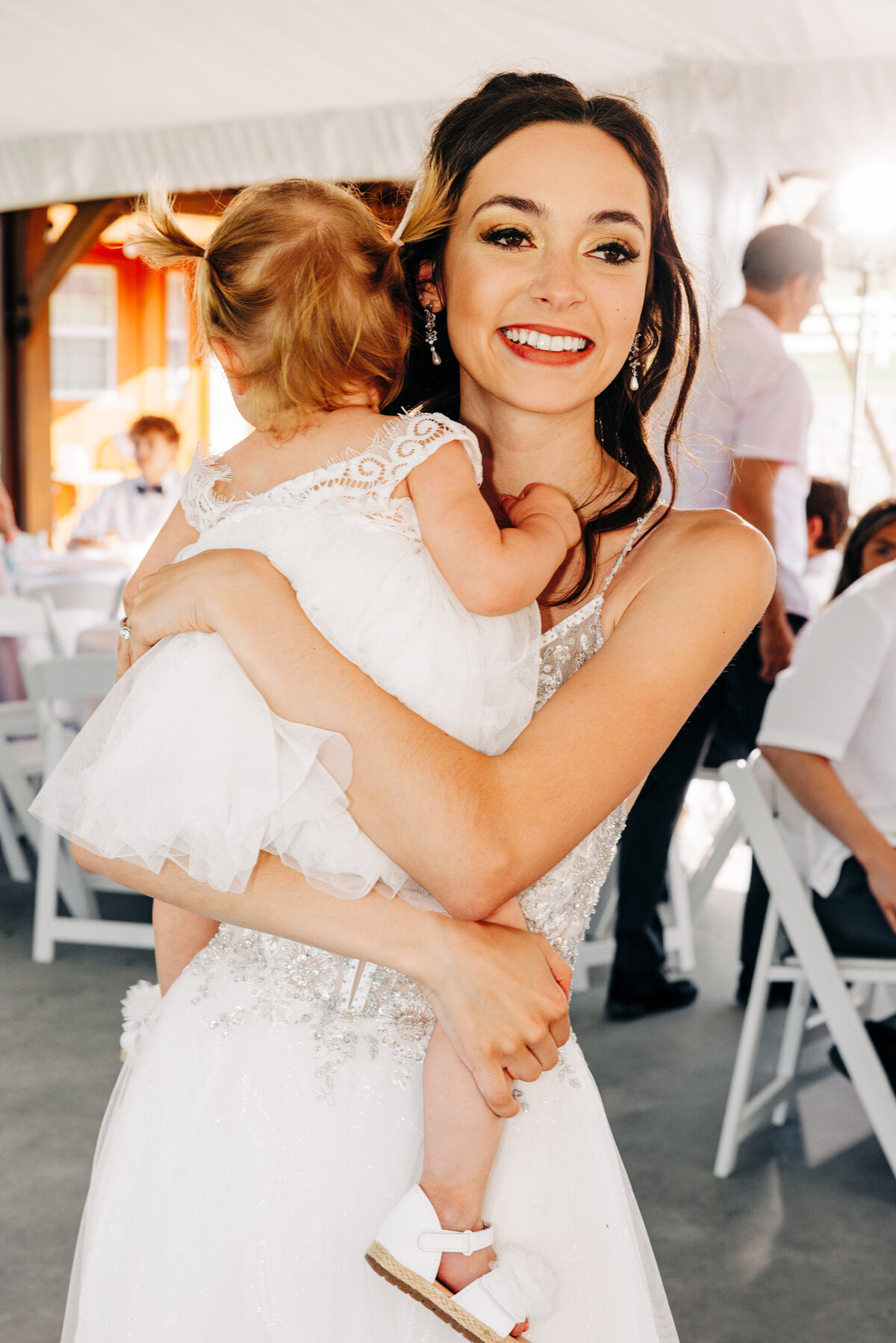 Bride holding baby daughter during reception at Flathead Lake Forevers