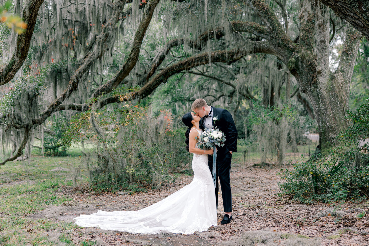 Bride and Groom kissing under the oak trees