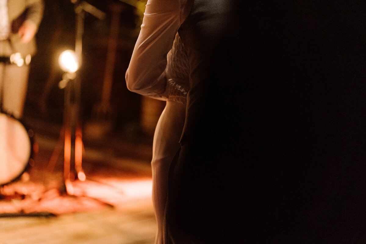 Detail shot van bruidspaar die met elkaar danst op het avondfeest. 